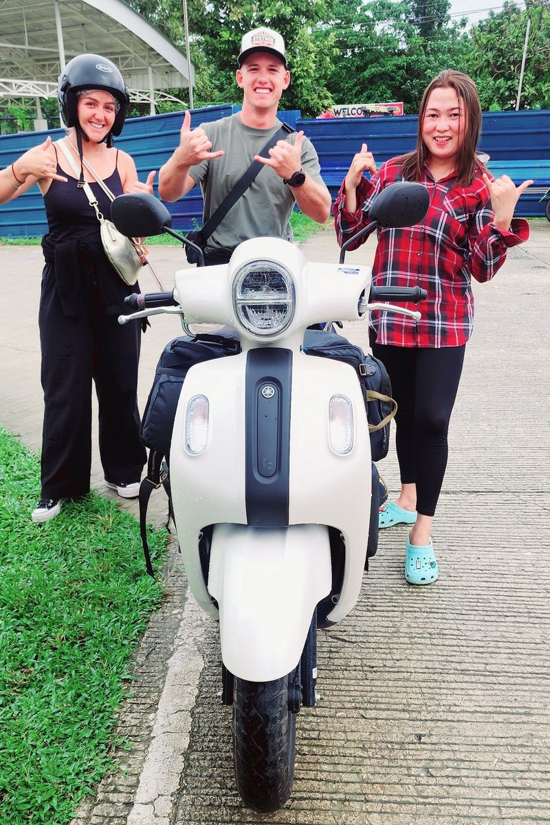 Cream Yamaha Fazzio seen front-on with three smiling people giving shakas